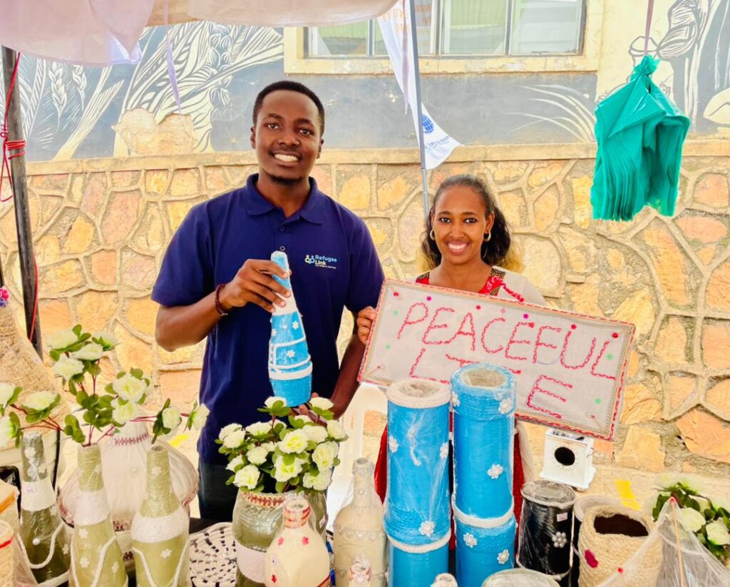 RefugeeLink's Outreach Lead, Clinton Murungi(left) posing with a vendor at the trade exhibition held at Motiv Bugolobi