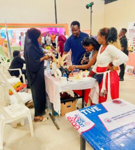 RefugeeLink's Outreach Lead, Clinton Murungi(3R) posing with a vendor at the trade exhibition held at Motiv Bugolobi