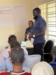 RefugeeLink's Garang addressing attendees of an FGD that was hosted at their premises