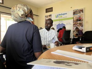 RefugeeLink's Corinne with a participant at the FGD that was hosted at their premises